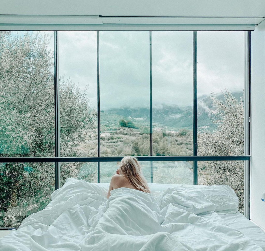 Chica despertando de la cama disfrutando de las vistas en VIVOOD