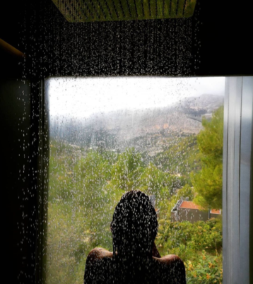 Chica disfrutando de la ducha panorámica con vistas al exterior en VIVOOD